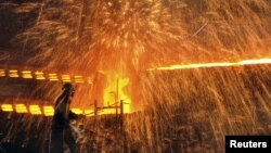 A Chinese laborer works at a steel factory in Dalian, Liaoning province, December 4, 2012. 