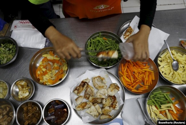 Seorang pekerja MyMeals, sebuah layanan pesan-antar makanan, menyiapkan makan malam untuk penderita diabetes di kawasan Cikokol dekat Jakarta, 25 April 2016. (Foto: REUTERS/Beawiharta)