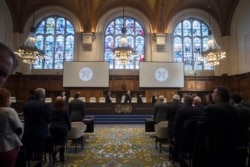 NETHERLANDS -- The delegations of the U.S., front left, and the Islamic Republic of Iran, front right, rise as judges, rear, enter the International Court of Justice, or World Court, in The Hague, October 3, 2018.