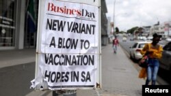 FILE PHOTO: A woman walks past newspaper billboards during the coronavirus disease (COVID-19) outbreak in Johannesburg, South Africa, Feb. 8, 2021.