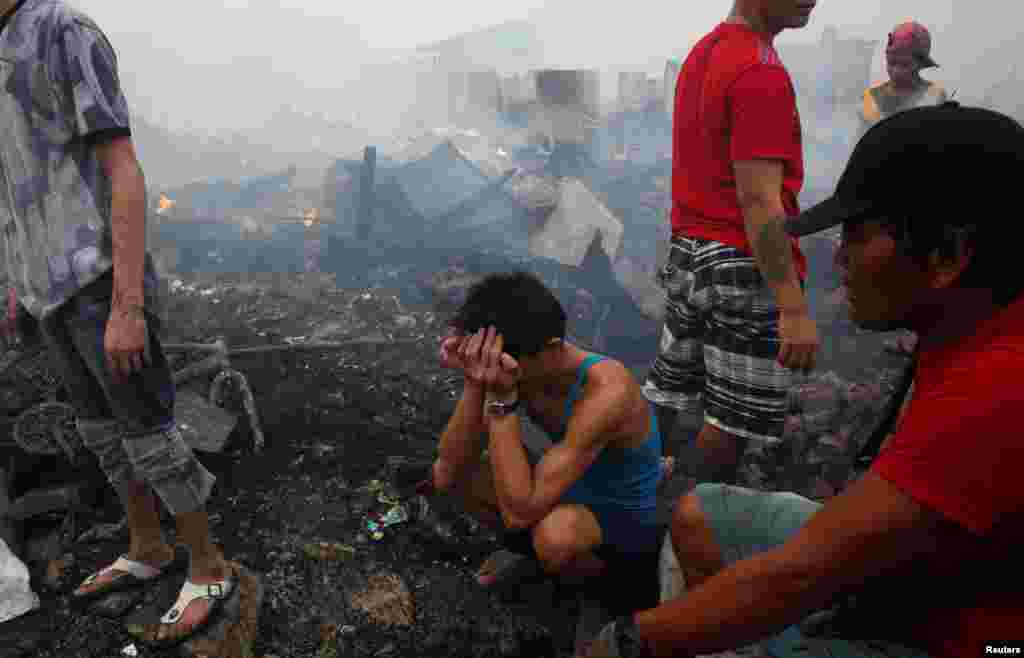 قربانیان آتش سوزی در شهر ناووتاس در کشور فیلیپین منتظر هستند که بعد از اطفای حریق ببینند چیزی برای شان مانده یا نه. 