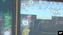 Bullet holes in window of a civilian bus
