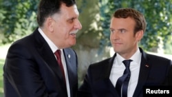 Le président français Emmanuel Macron au côté du Premier ministre libyen Fayez al-Sarraj (à gauche), après un accord sur un accord politique destiné à mettre fin à la crise en Libye à La Celle-Saint-Cloud, près de Paris, le 25 juillet 2017.
