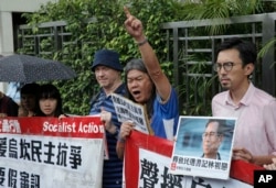 Protesters holding signs and a picture of Wukan village chief Lin Zulian are seen at a solidarity rally outside the Chinese central government's liaison office in Hong Kong, Sept. 9, 2016.