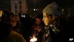 Migrants rights activists hold candles during a gathering outside Calais, France, Nov. 25, 2021. At least 27 migrants died when their small boat sank in an attempted crossing of the English Channel, a French government official said Nov. 24, 2021.