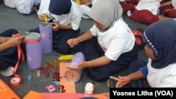 Para pelajar tingkat Sekolah Dasar ikut lomba menghias celengan dalam rangkaian kegiatan Hari Anak Nasional di Sigi, Sulawesi Tengah, 18 Juli 2019. (Foto: VOA / Yoanes Litha)