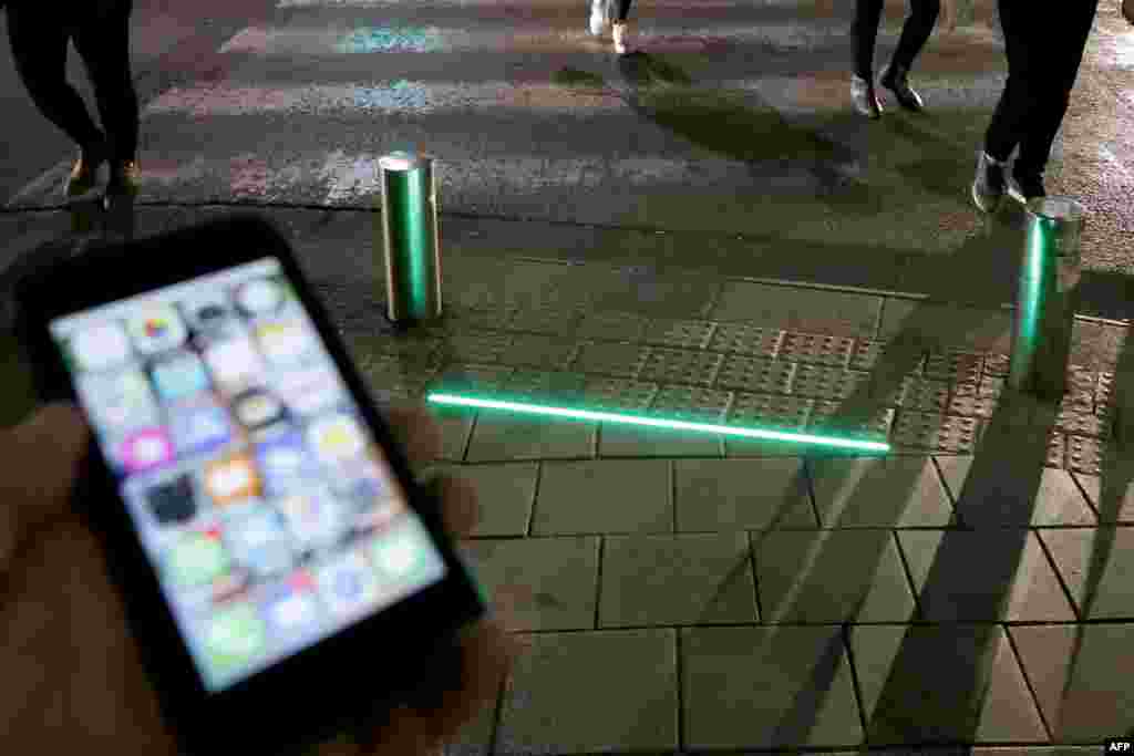 LED ground-level lights are installed to warn texting pedestrians before crossing the road in the coastal city of Tel Aviv, Israel.