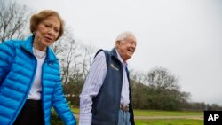 FILE - In this Feb. 8, 2017, file photo former President Jimmy Carter, right, and his wife Rosalynn arrive for a ribbon cutting ceremony for a solar panel project on farmland he owns in their hometown of Plains, Georgia, USA.