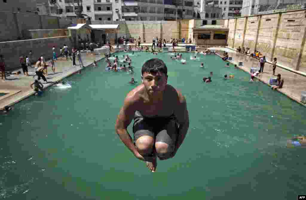 A Syrian youth dives into a swimming pool as people enjoy a day out in the northern city of Aleppo. The new head of the Syrian National Coalition Ahmad al-Assi has backed calls for a truce from U.N. chief Ban Ki-Moon during the holy month of Ramadan. 