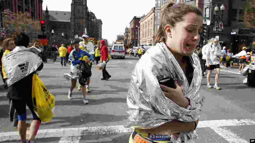 Uma corredora deixa a maratona de Boston a chorar na sequ&ecirc;ncia da dupla explos&atilde;o (15 Abril de 2013). 