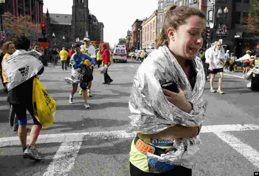 Mkimbiaji wa Marathon asiyejulikana akiondoka kwenye mashindano akilia karibu na uwanja wa Copley baada ya milipuko huko Boston, Aprili 15, 2013.