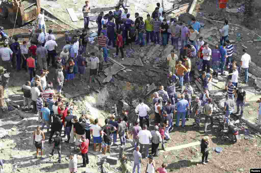 Los residentes observan el crater que dejó una de las explosiones frente a una mezquita en la zona norte de la ciudad de Trípoli, en el Líbano.