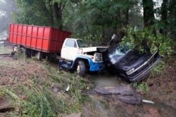 Un camion et une voiture se trouvent dans un ruisseau, dimanche 22 août 2021, après avoir été emportés par les eaux la veille à McEwen, Tennessee.