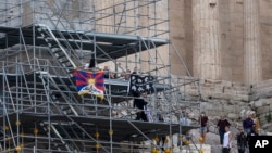 2022 베이징 동계올림픽 개최에 반대하는 인권운동가들이 17일 그리스 아테네 아크로폴리스에서 티베트 깃발과 현수막을 내걸고 시위하고 있다.