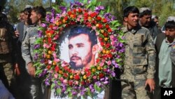 Military personnel held a photo of Gen. Abdul Raziq, Kandahar police chief, who was killed by a guard, during his burial ceremony in Kandahar, Afghanistan, Oct. 19, 2018.