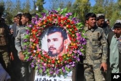 Military personnel held a photo of Gen. Abdul Raziq, Kandahar police chief, who was killed by a guard, during his burial ceremony in Kandahar, Afghanistan, Oct. 19, 2018.