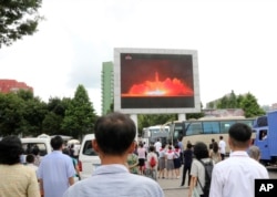People watch a news broadcast of a missile launch in Pyongyang, North Korea, July 29, 2017. North Korean leader Kim Jong Un said Saturday the second flight test of an intercontinental ballistic missile demonstrated his country can hit the U.S. mainland.