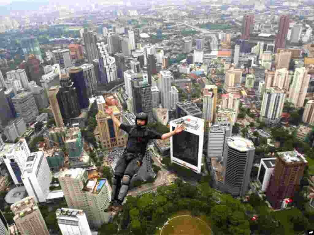 BASE jumper Walter Hilscher of Germany leaps from Kuala Lumpur Tower during the KL Tower International Jump in Kuala Lumpur, Malaysia, Thursday, Oct. 7, 2010. BASE stands for the places such jumpers usually leap from: buildings, antennae, spans and earth.