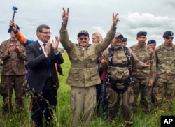 U.S. World War II D-Day veteran Tom Rice, from Coronado, California, flashes victory signs after parachuting in a tandem jump into a field in Carentan, Normandy, France, June 5, 2019.