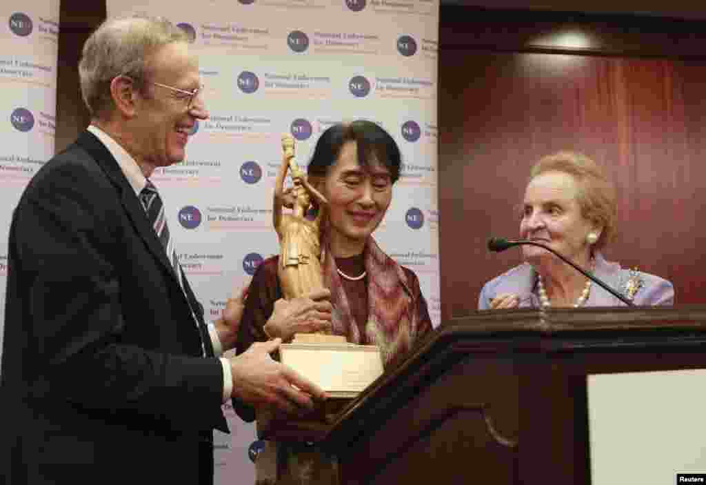 Burma&#39;s opposition leader Aung San Suu Kyi receives the National Endowment for Democracy award from Carl Gershman (L), President of the National Endowment for Democracy, and former Secretary of State Madeleine Albright during a ceremony in Washington, September 20, 2012.