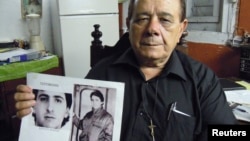 Raul Borges, 74, memegang foto anaknya Ernesto Borges di rumahnya di Havana (2/1). Ernesto telah dipenjara di Kuba selama 16 tahun setelah mencoba membocorkan rahasia ke seorang diplomat AS di Kuba. 