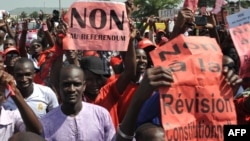 FILE - Protestors carry a sign reading "No to the referendum" and "No to Constitutional revision" during a demonstration against a referendum on a constitutional revision on July 1, 2017, in Bamako. 