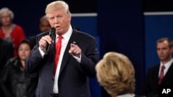 Republican presidential nominee Donald Trump points at Democratic presidential nominee Hillary Clinton as he speaks during the second presidential debate at Washington University in St. Louis, Oct. 9, 2016.