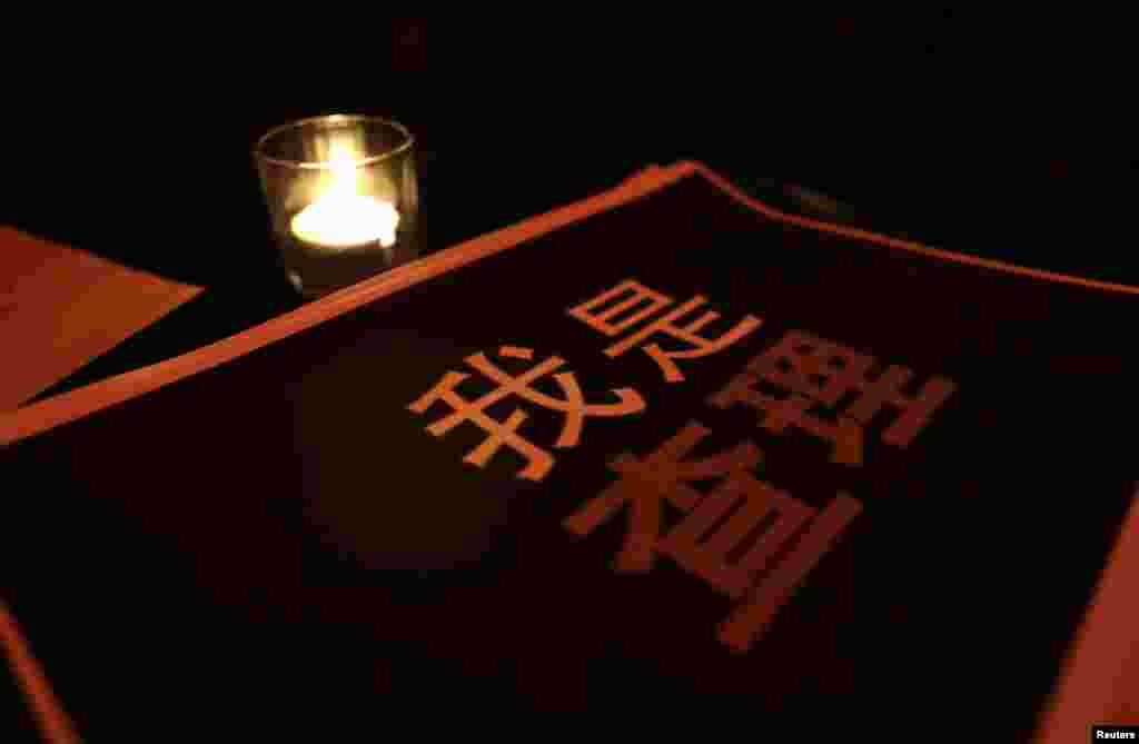 A placard that reads &quot;I am Charlie&quot; is placed next to a candle during a campaign at a bookstore in Beijing, China, Jan. 8, 2015.
