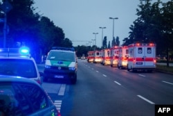 Police cars and ambulances are seen near a shopping mall in Munich on July 22, 2016 following shootings.