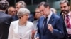 British Prime Minister Theresa May, center left, speaks with Spanish Prime Minister Mariano Rajoy, center right, as they arrive for a round table meeting at an EU Summit in Brussels, June 23, 2017. 