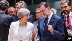 British Prime Minister Theresa May, center left, speaks with Spanish Prime Minister Mariano Rajoy, center right, as they arrive for a round table meeting at an EU Summit in Brussels, June 23, 2017. 