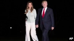 President Donald Trump and first lady Melania Trump walk from Marine One across the South Lawn to the White House in Washington, May 27, 2017, as they return from Sigonella, Italy.