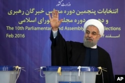In this photo released by official website of the office of the Iranian Presidency, President Hassan Rouhani waves to media after casting his vote for parliamentary and Experts Assembly elections in Tehran, Iran Friday, Feb. 26, 2016.