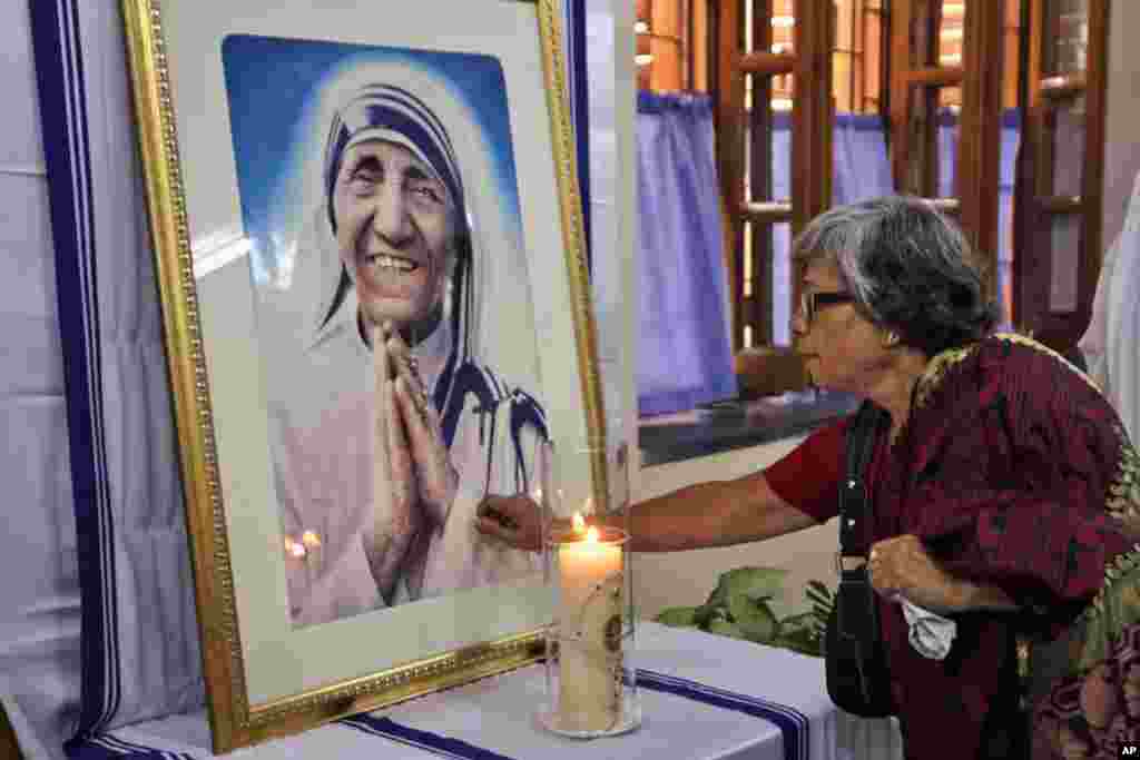 An Indian Catholic woman offers prayers as she touches a portrait of Mother Teresa on the 17th anniversary of her death at the Missionaries of Charity in Kolkata, India.