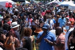 FILE - A crowd of people take part in a Juneteenth commemoration at Leimert Park Plaza in Los Angeles on June 19, 2021. California's major population centers of Los Angeles and the San Francisco Bay area lost population in the same year, according to data