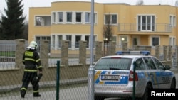 A firefighter walks past the site of an explosion at the Palestinian ambassador's residence in Prague January 1, 2014.