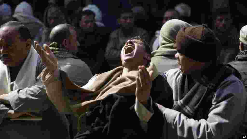 Egyptian Coptic men mourn for 21 Coptic Egyptian men slain by Islamic State militants in Sirte, Libya, at the Virgin Mary Church in the village of el-Aour, near Minya, 220 kilometers (135 miles) south of Cairo, Egypt, Feb. 16, 2015.