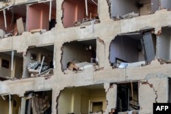 FILE - A woman reacts in her damaged apartment on the explosion site, Nov. 4, 2016 after a strong blast in the southeastern Turkish city of Diyarbakir.