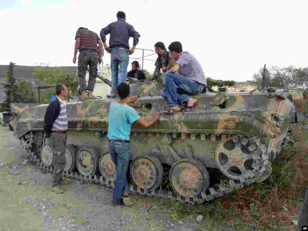 2012年10月7日反政府的敘利亞自由軍戰士察看他們在伊德利卜城繳獲的政府軍坦克。(美聯社)