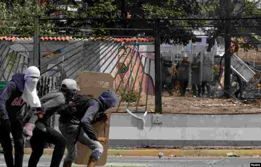 Opposition supporters face members of the National Guard during a rally against the government of Venezuela's President Nicolas Maduro and to commemorate May Day in Caracas, May 1, 2019. 