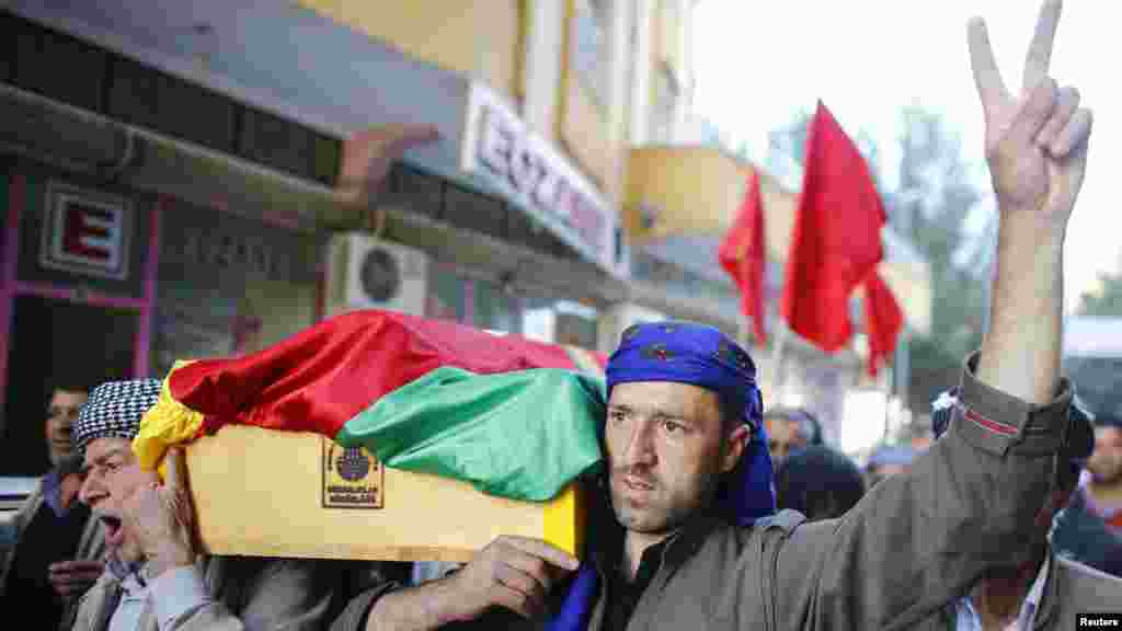 Des Kurdes portent le cercueil du combattant Ahmed Mustafa, qui est mort après avoir été blessé au combat contre les forces du groupe Etat islamique dans la ville syrienne de Koban, le 12 novembre 2014.