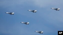 FILE Chinese JH-7 fighter-bombers fly in formation during a parade over Beijing, China, Sept. 3, 2015. 