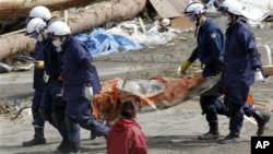 Police officers carry a body during a search and rescue operation in the earthquake and tsunami-devastated city of Rikuzentakata, Iwate Prefecture, northeastern Japan, March 23, 2011