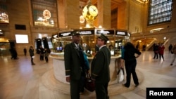 Train conductors talk to each other shortly before the first Metro North commuter train to leave Grand Central Station in New York, October 31, 2012.