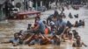 Rescuers pull a rubber boat carrying residents through a flooded street after Typhoon Vamco hit in Marikina City, suburban Manila, Philippines.