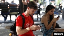 Miguel Hayes, who writes for the blog La Joven Cuba, connects to the internet at a hotspot in a park, in Havana, Cuba, Feb. 5, 2018. 