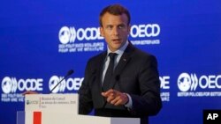 FILE - French President Emmanuel Macron delivers a speech at the OECD ministerial council meeting in Paris, May 30, 2018. 