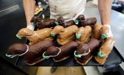 Baker Tim Kortuem poses with lamb-shaped easter cakes with protective masks at his bakery Schuerener Backparadies as the spread of the coronavirus disease continues in Dortmund, Germany, April 9, 2020.