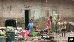 Warga membersihkan rumah rusak akibat banjir di Tapanuli Tengah, Sumatera Utara, Rabu, 29 Januari 2020. (Foto: AP)