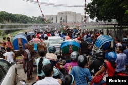 People and vehicles gather outside the Bangladeshi parliament building a day after the resignation of Prime Minister Sheikh Hasina, in Dhaka, Bangladesh, on Aug. 6, 2024.